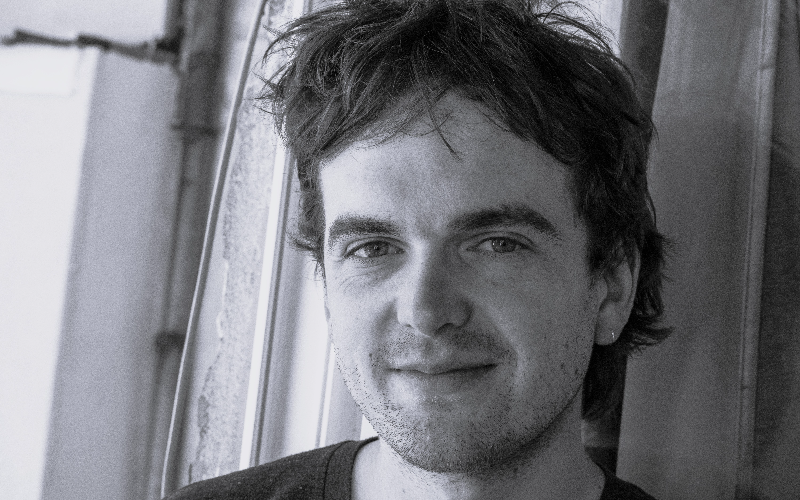 a close up black and white image of a man with dark hair