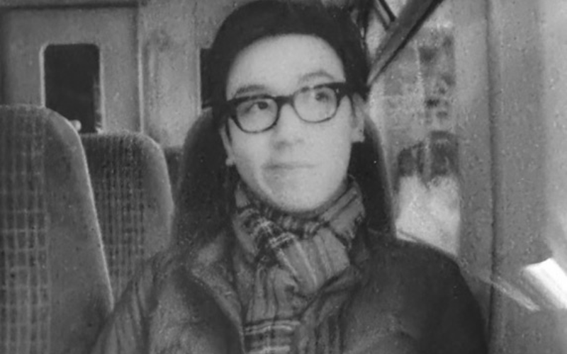 a black and white image of a young Chinese man sat on a train