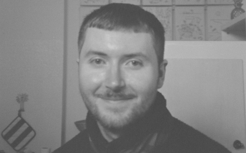 a black and white close up of a young man smiling 