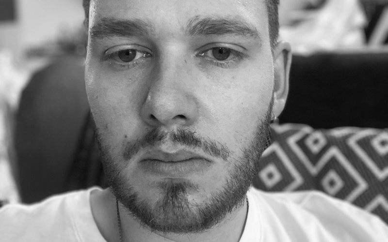 a close up of a young man in a white tshirt