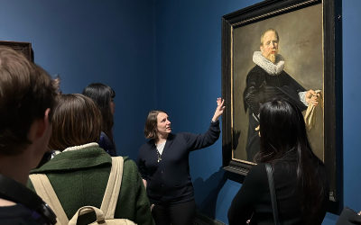 A lecturer points at an image in an art exhibition