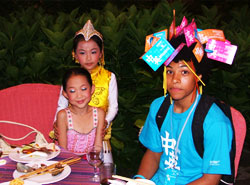 Two beautifully dressed party performers found it highly amusing to decorate Ashley, one of our students, with flags of friendship.