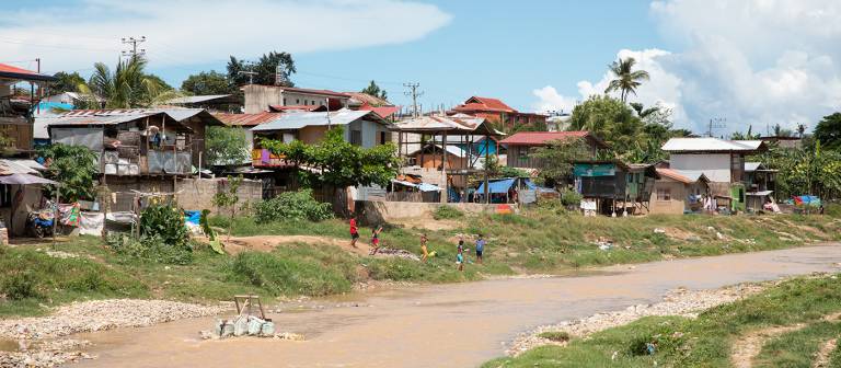 Photo of some housing alongside a river bank in Cebu, Philippines