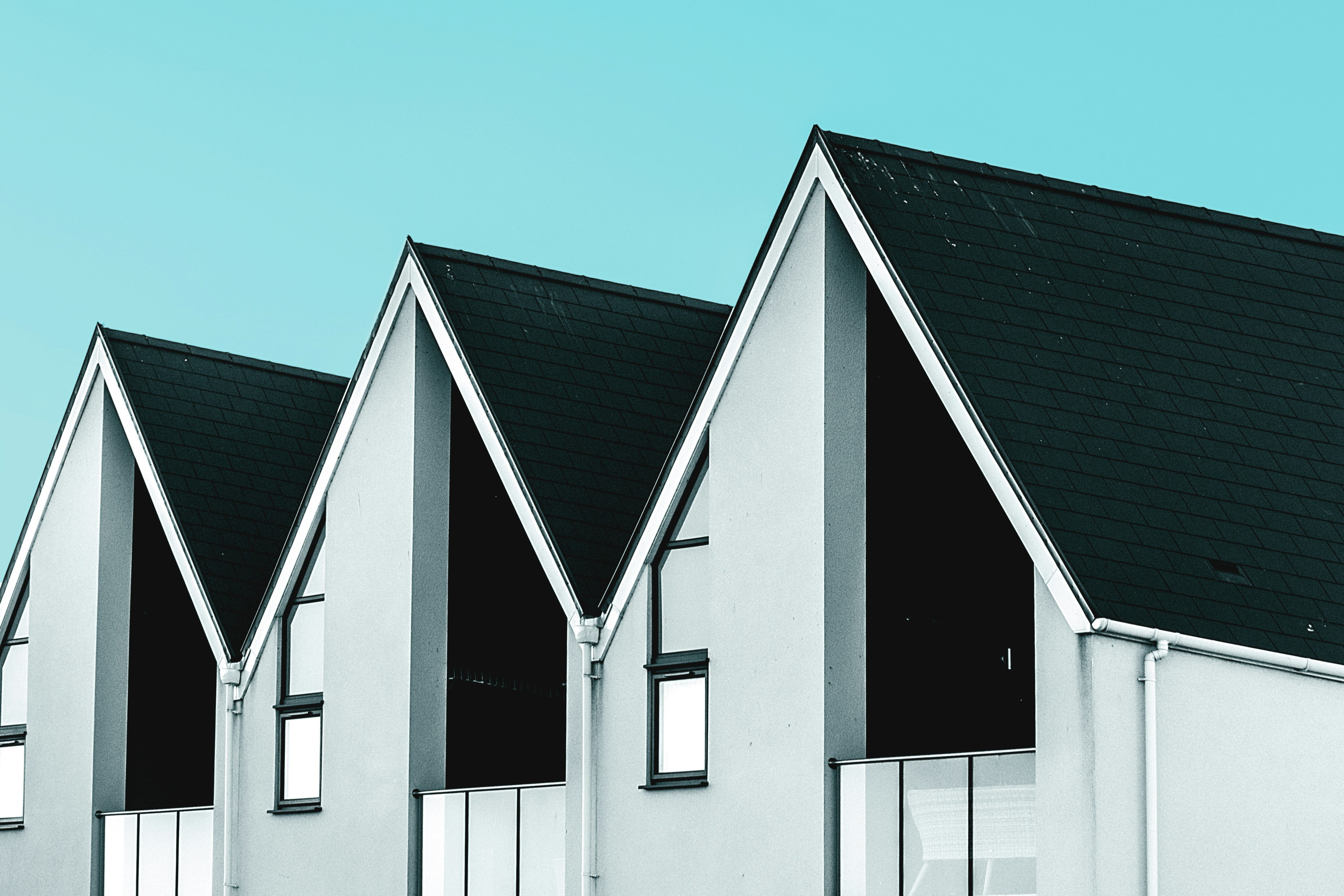 a row of modern houses against a stark blue sky.