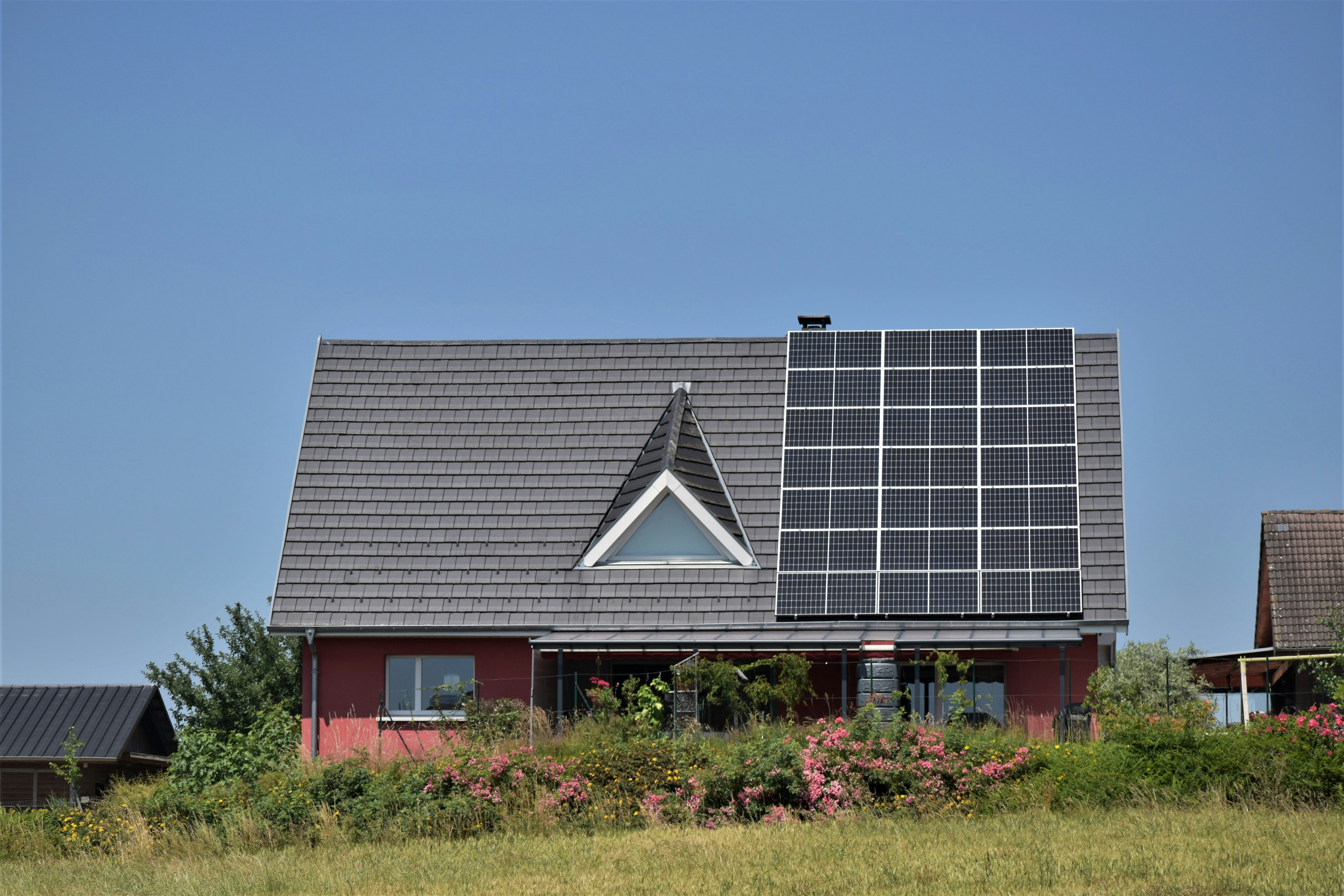 a house with four solar panels on its roof.