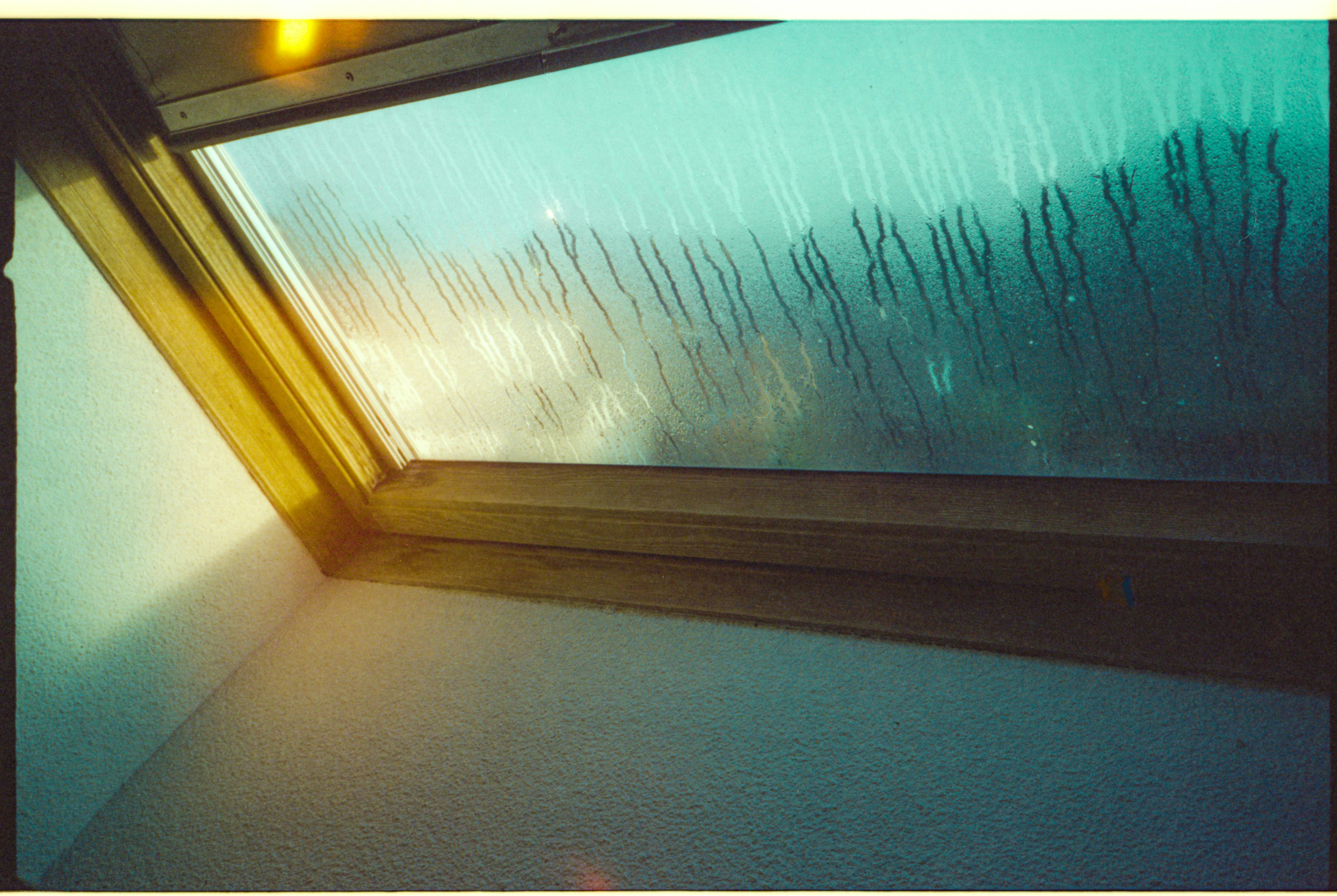 A misted window with droplets of water on it.