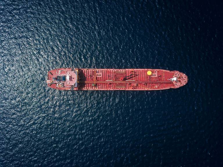 A photograph of a shipping tanker from above, surrounded by empty waters