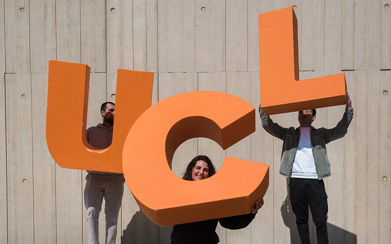 Students holding the letters UCL