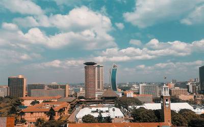 Nairobi City skyscrapers against a bright blue sky with a smattering of clouds