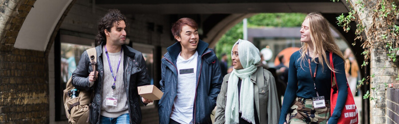 A group of students walking and talking on the UCL campus