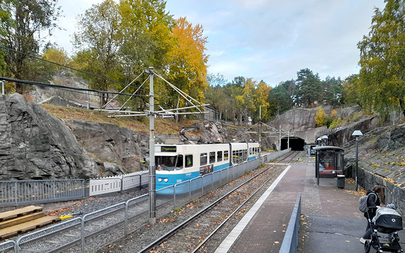 Image of train tracks with blue and white train passing through the station