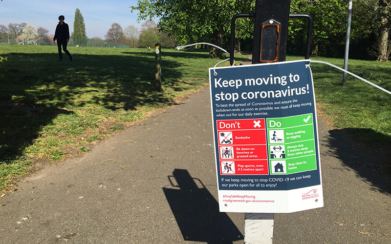 Picture of Covid-19 public announcement signs providing guidance on how to stop the spread of covid in a public park