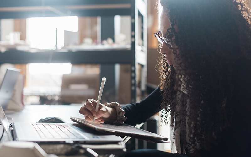 A student writing at a desk