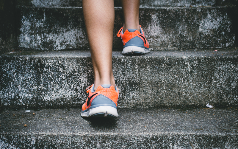 Close up of person wearing trainers walking up steps