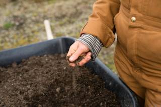 A woman holding soil