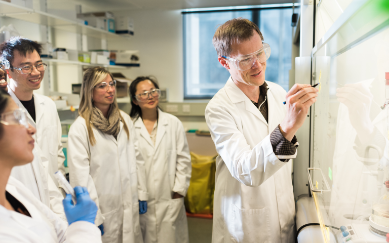 Image of MSc students in the lab with professor 