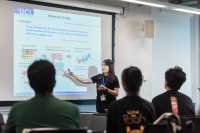 Image of a lecturer in front of a powerpoint presentation