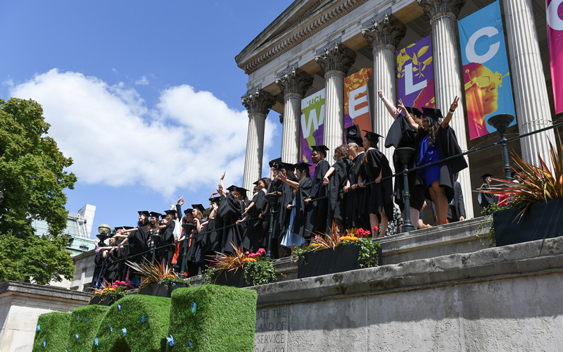 Group of students celebrating graduation at UCL Portico