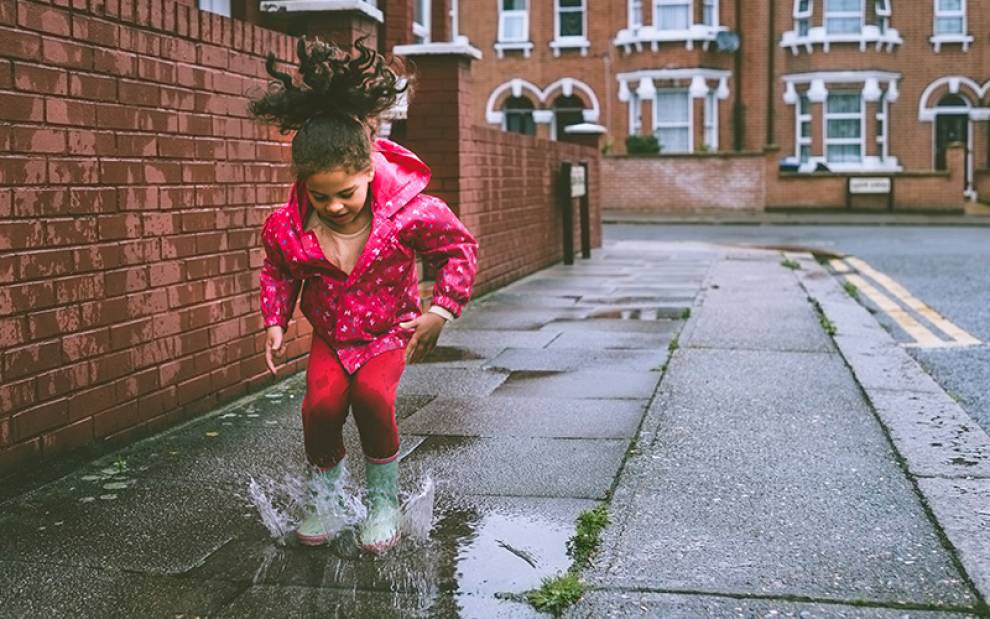 Child splashing in puddle