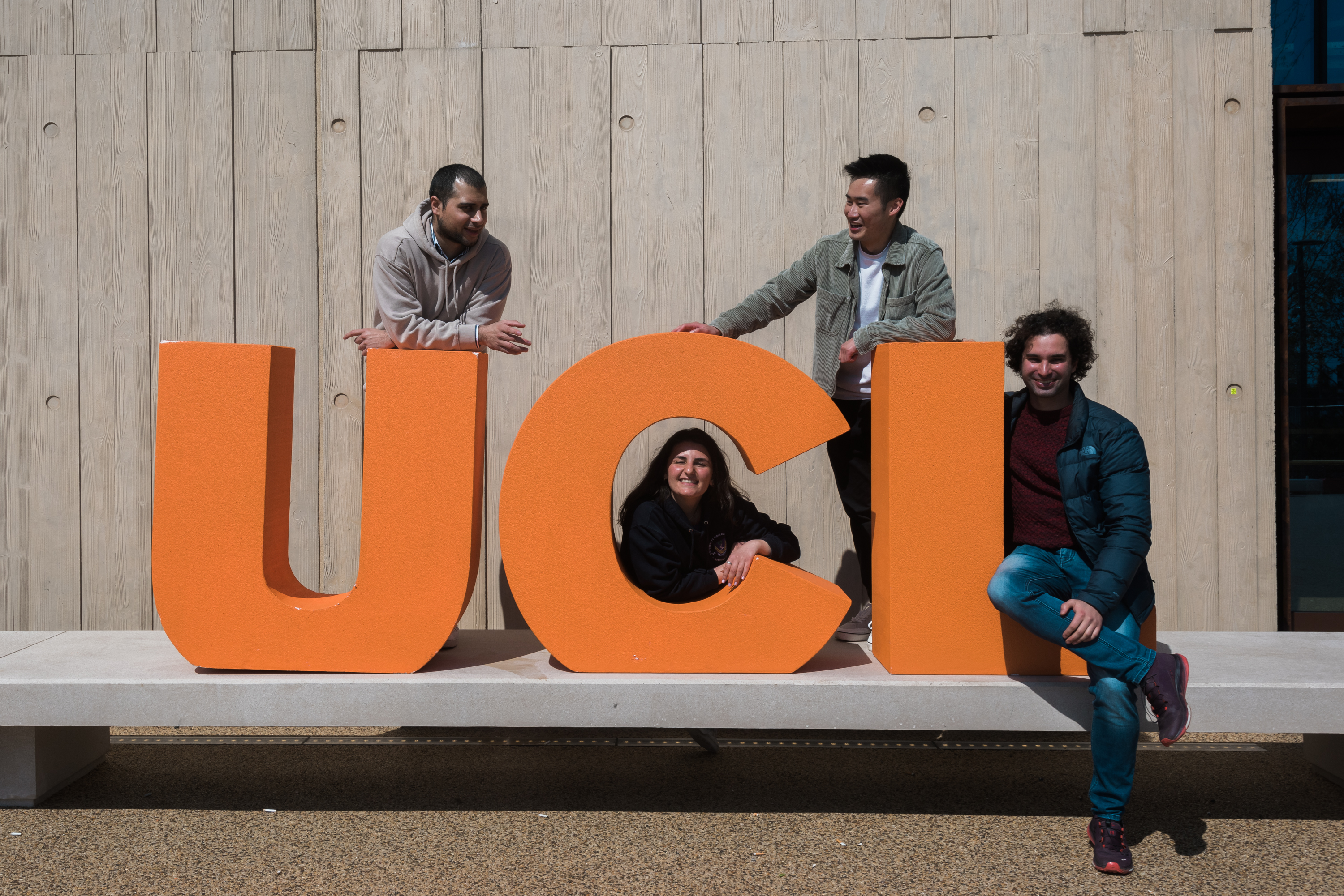 Photographic image of large UCL letters with students posing between