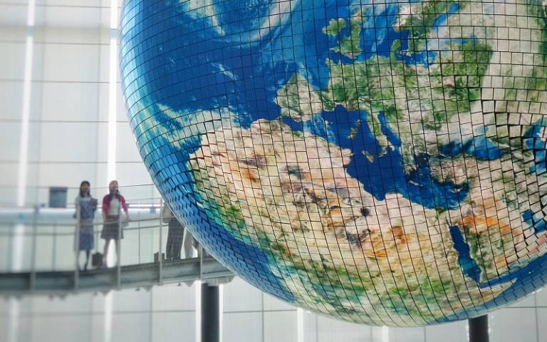 Two girls looking at large globe