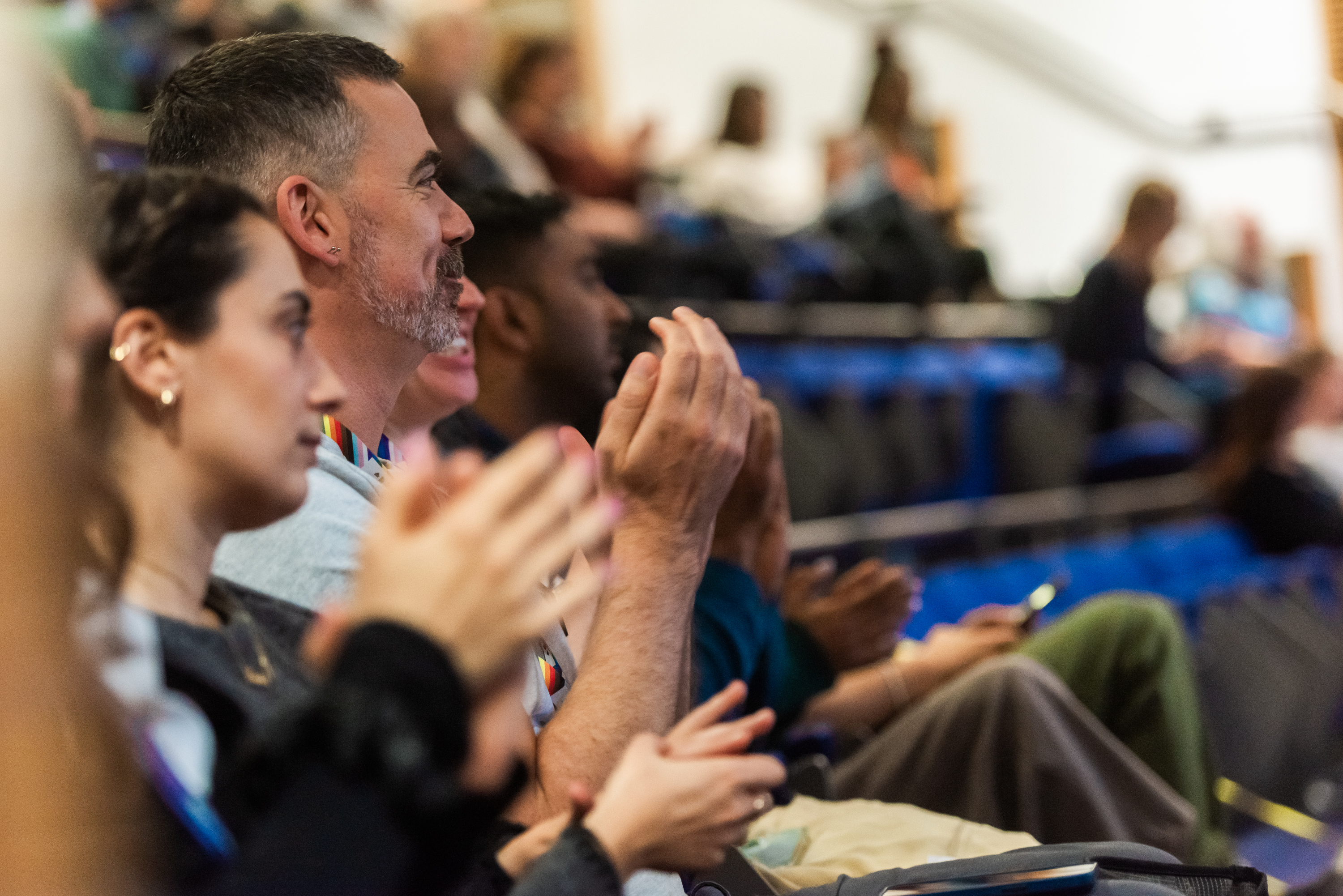 People clapping whilst watching a lecture