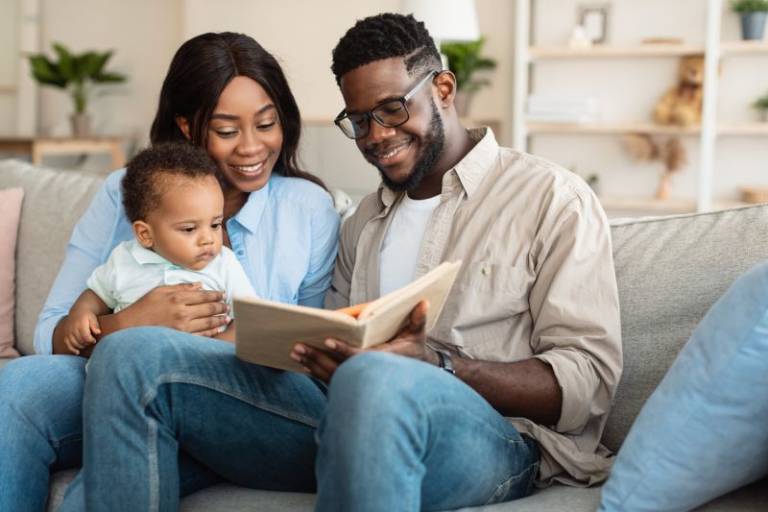 Mother, Father and baby reading a book 
