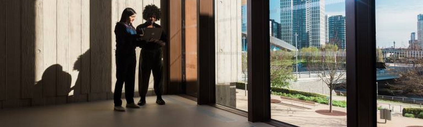 People in shadow in large pillared building