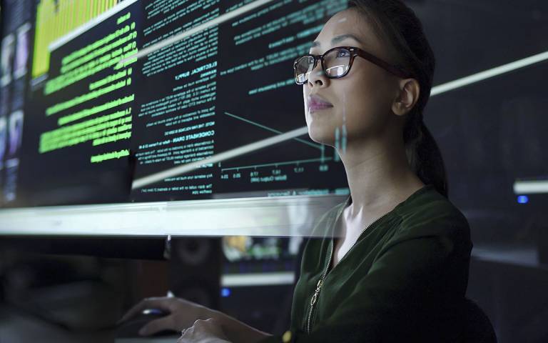 A woman looking at an overlay of computer code