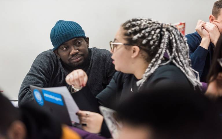 Two students in class discussing