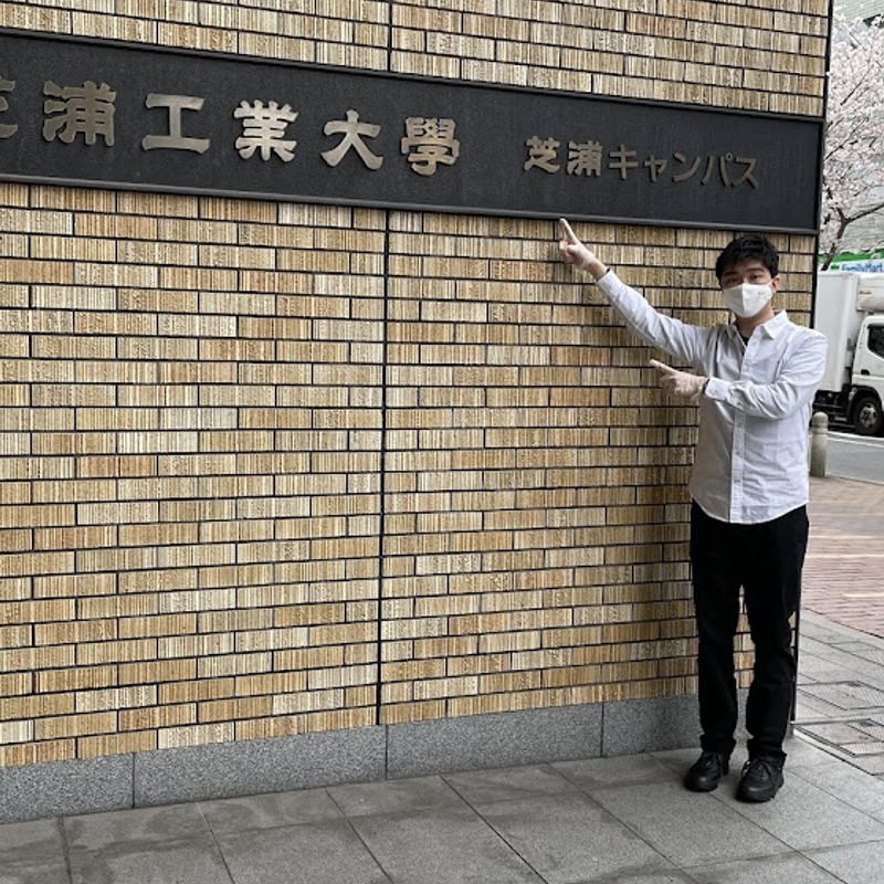 Yoshiki stood by a sign written in Japanese
