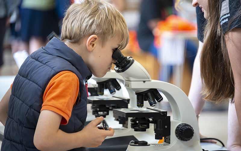 boy looking down microscope 