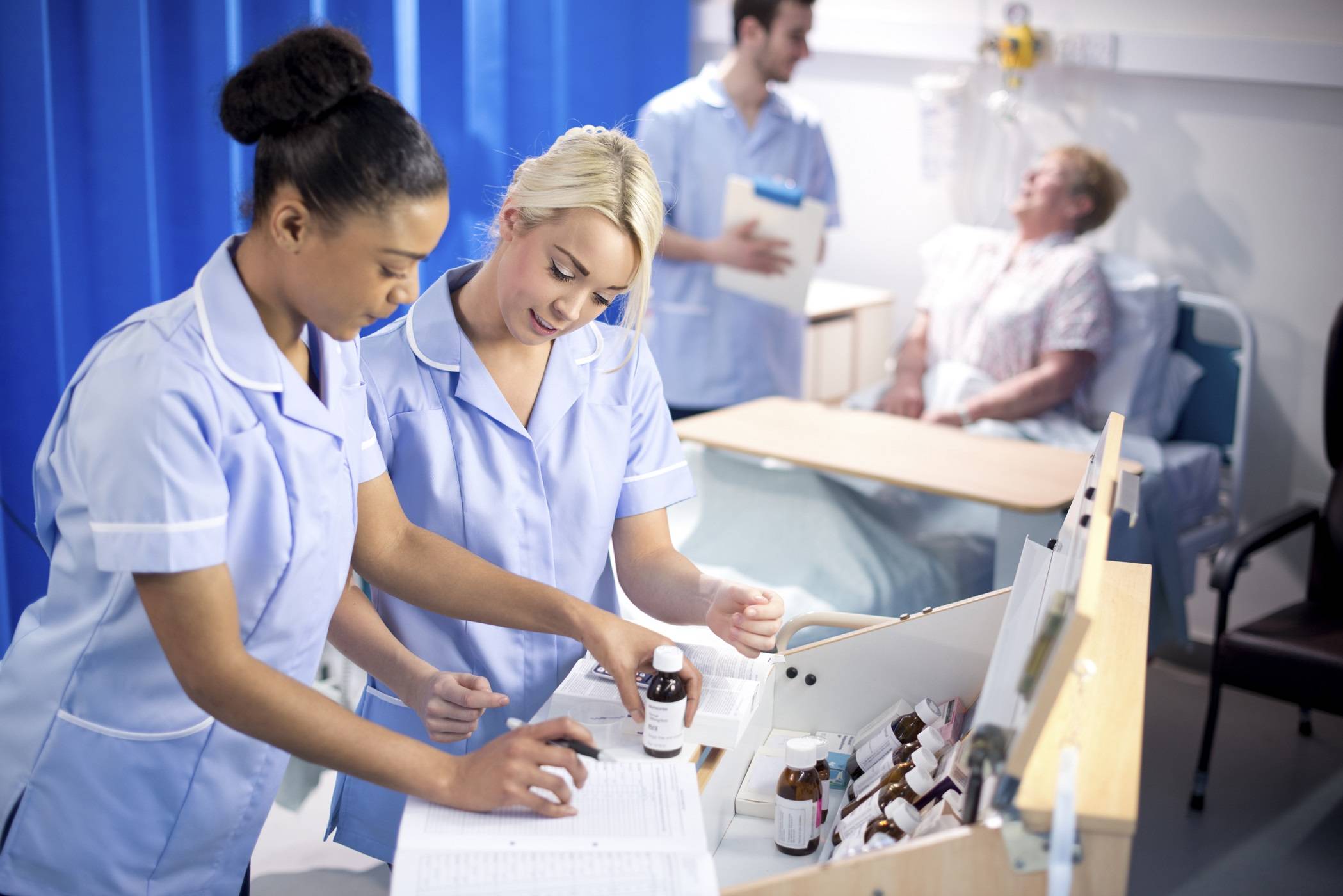 Nurses looking at medications on a ward round