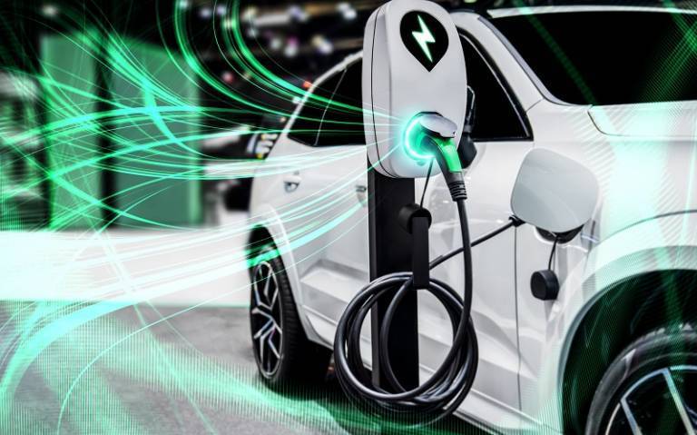 A white electric vehicle being charged