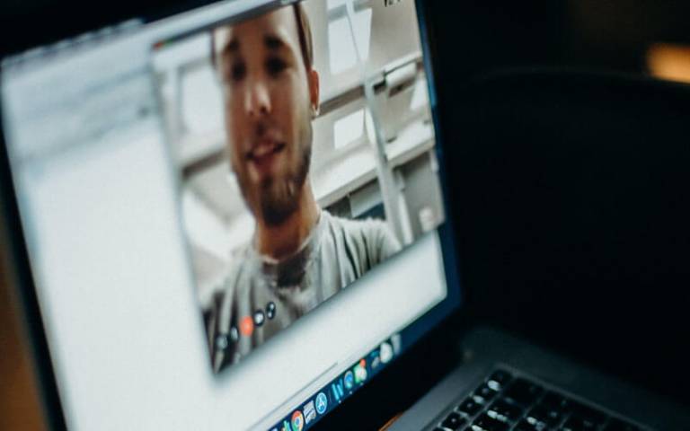 Laptop screen showing a Zoom call with a man on-screen