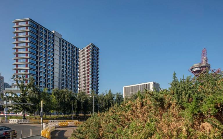 One Pool Street and the red arcelor mittal tower in the background, with long wheat grass in the foreground