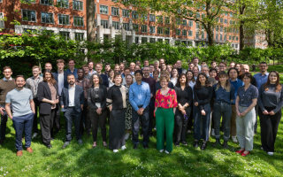 A large group of staff memeber stand in a London park