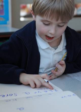 Boy writing at Reading Recovery lesson