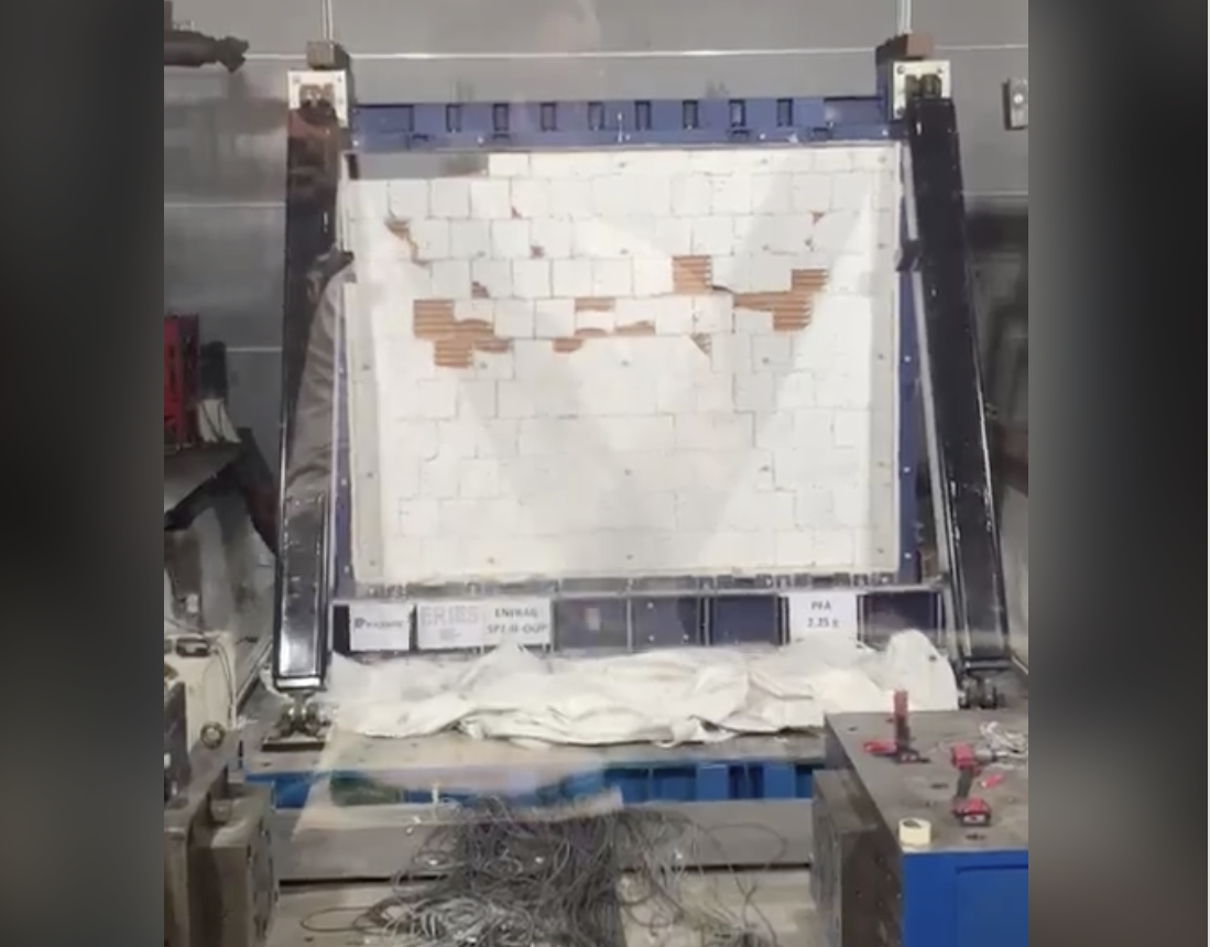 Machine shaking a small wall to replicate an earthquake