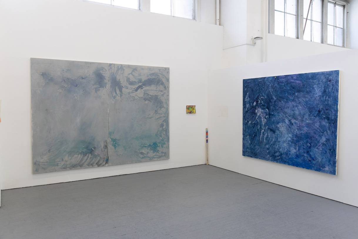 Installation photo of two large abstract paintings, and two smaller works