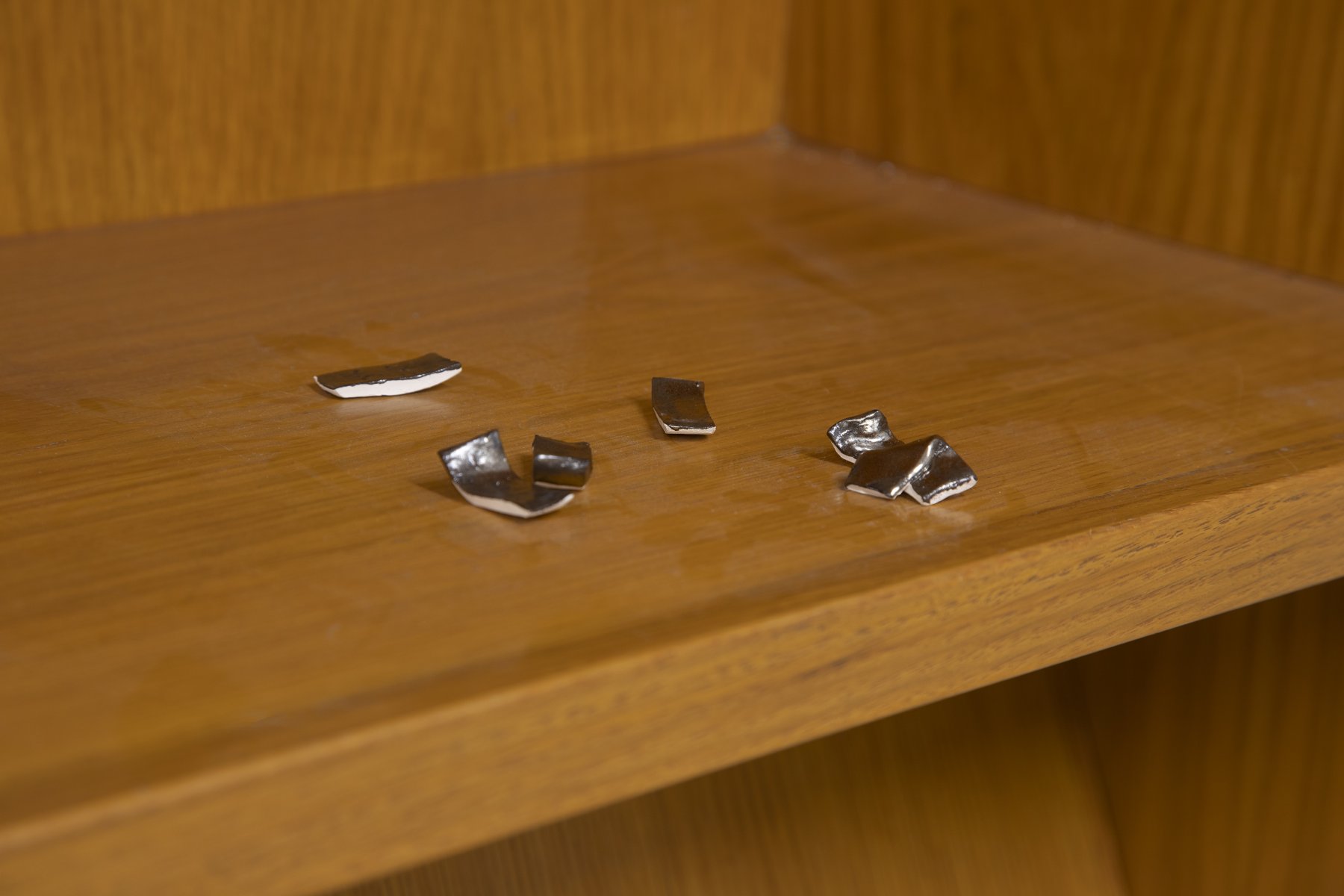 Close up of wooden shelf with small brass tokens.