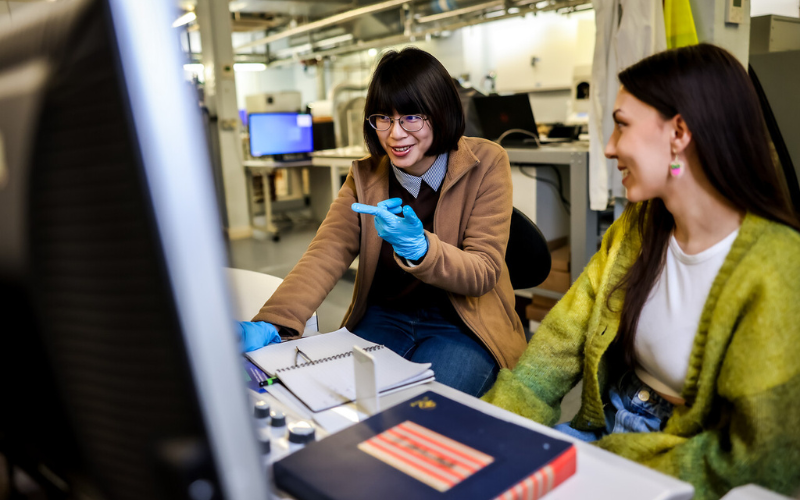 Image shows a student helping another student 