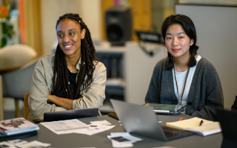 Image shows two students sitting and engaged in a discussion 