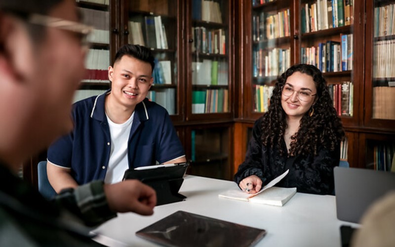 students talking at a desk.