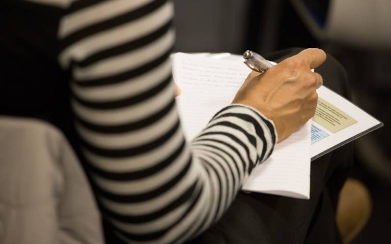 Person writing notes at an Arena event 