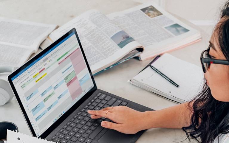 Student on laptop with books open