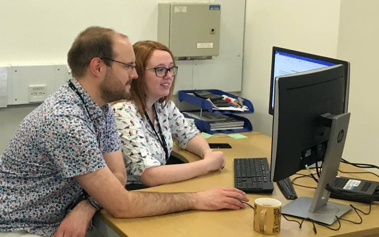 Staff and students at a computer 