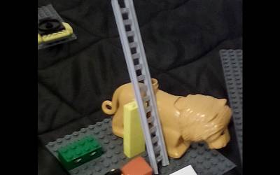 A lego model with a lion standing next to a ladder