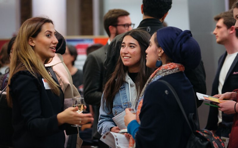 three people chatting at a science event.