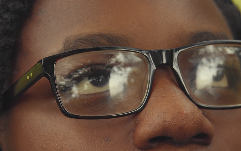 Young black man looking up in black glasses